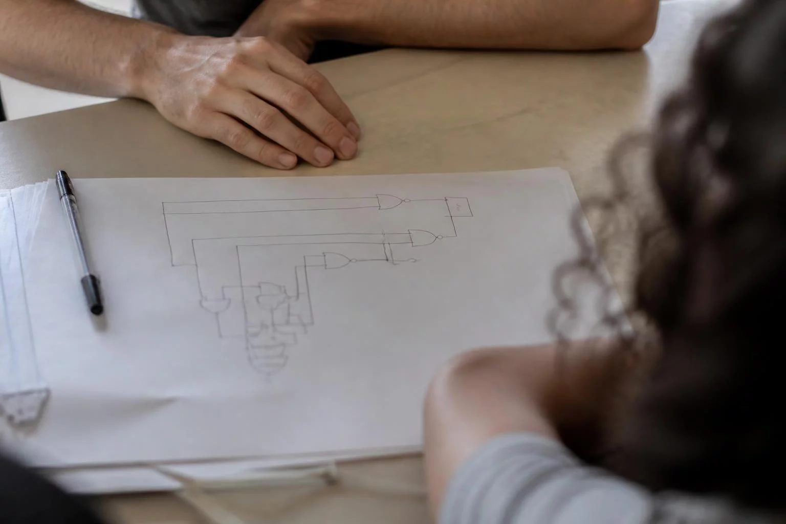 Vista de cima de uma mesa com um diagrama de lógica desenhado à mão